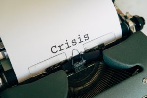 the word crisis written on a piece of paper in a typewriter